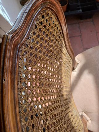 Silla antigua de madera con asiento tapizado.