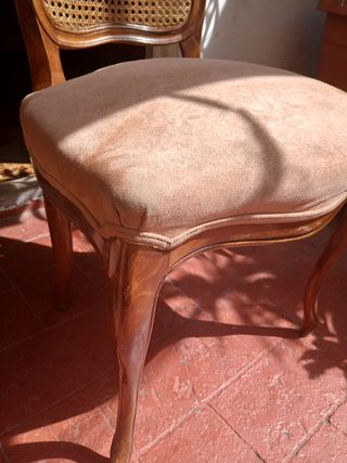 Silla antigua de madera con asiento tapizado.