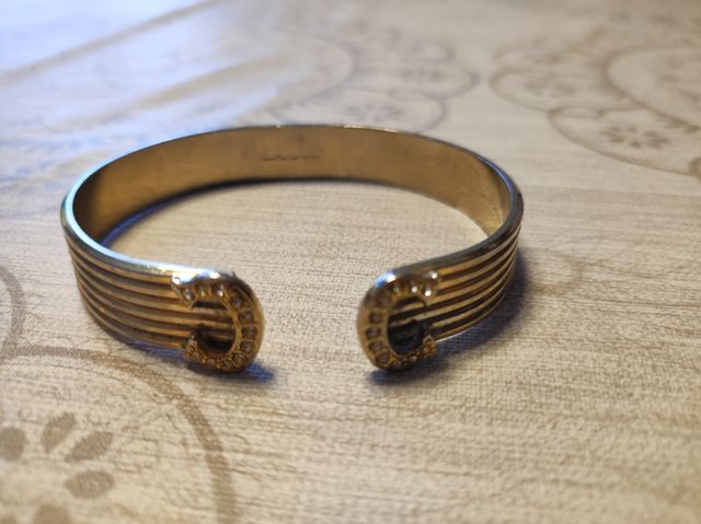 Pulsera metálica herraduras color dorado.