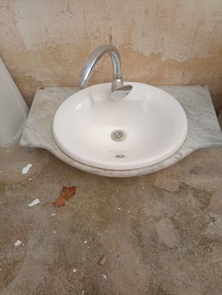 Lavabo antiguo con encimera de mármol y grifo