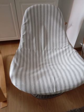 Butaca giratoria de tela gris y blanca.