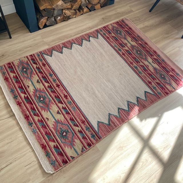 Alfombra beige y rosa de tela