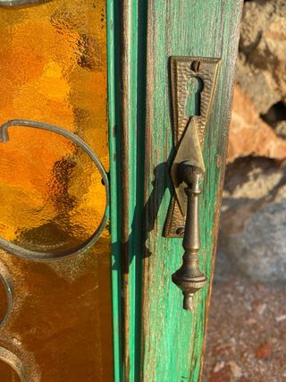 Puerta vintage verde madera, forja y cristal ámbar