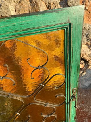 Puerta vintage verde madera, forja y cristal ámbar