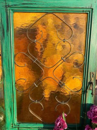 Puerta vintage verde madera, forja y cristal ámbar