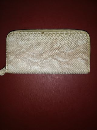 Cartera de mano beige con textura de piel de serpi