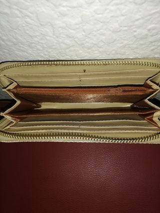 Cartera de mano beige con textura de piel de serpi