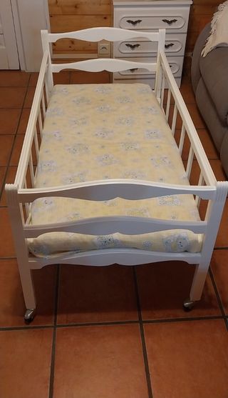 Cuna de bebé blanca con ruedas