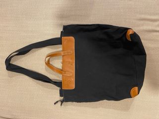 Bolso negro con asas de cuero y detalles