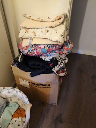 Caja con ropa, manta y cojín lactancia sábanas cun