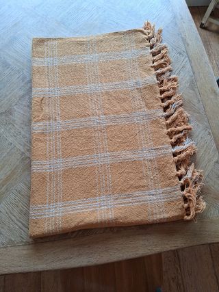 Tovaglia con quadri arancione-marrone e bianco.