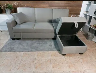 Sofá cama gris con puf y 2 cojines