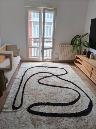 Alfombra grande beige con diseño negro