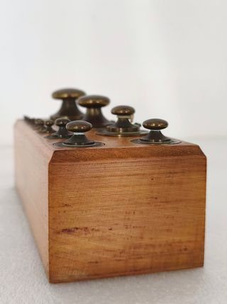 Antiche bilance con pesi in scatola di legno