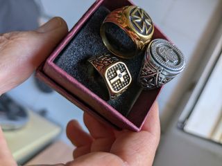 2Anillos .dorado cruz y brillo y el plata con mano