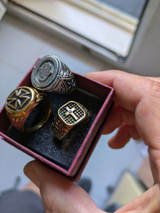 2Anillos .dorado cruz y brillo y el plata con mano