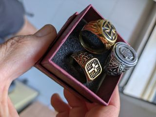 2Anillos .dorado cruz y brillo y el plata con mano