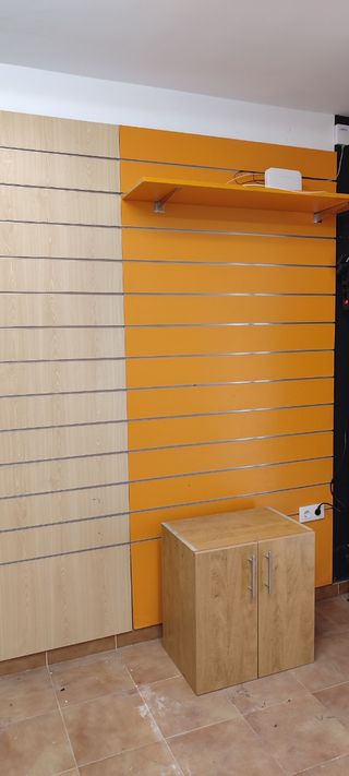 Mobiliario de negocio color naranja y madera.