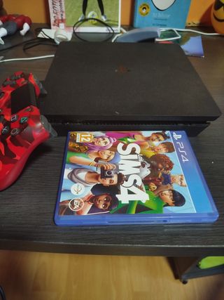 PS4 con mando camuflaje y Los Sims 4