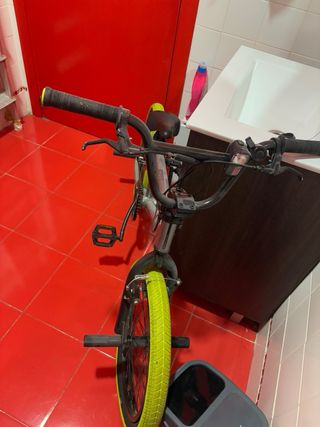 Bicicleta BMX plateada con ruedas amarillas