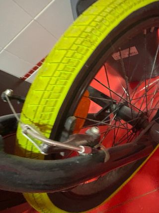 Bicicleta BMX plateada con ruedas amarillas