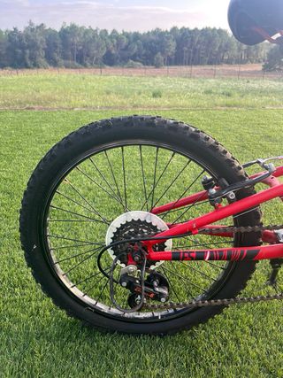 Bicicleta infantil roja de doble suspensión. 