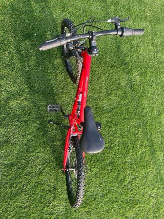 Bicicleta infantil roja de doble suspensión. 