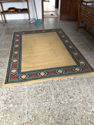 Alfombra amarilla con borde decorativo