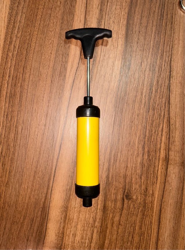 Inflador de pelotas de color amarillo.
