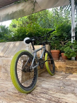 Bici BMX plateada con ruedas verdes
