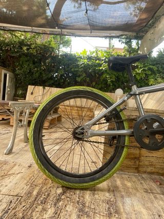 Bici BMX plateada con ruedas verdes