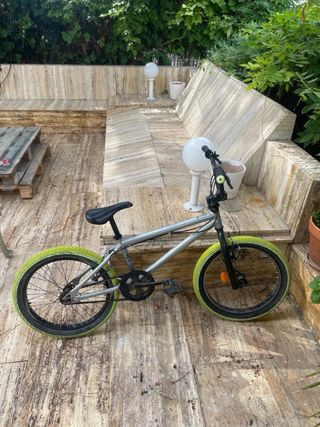 Bici BMX plateada con ruedas verdes