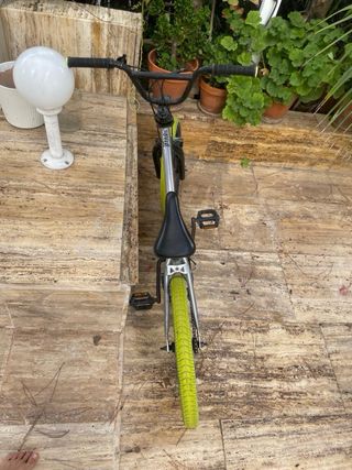 Bici BMX plateada con ruedas verdes