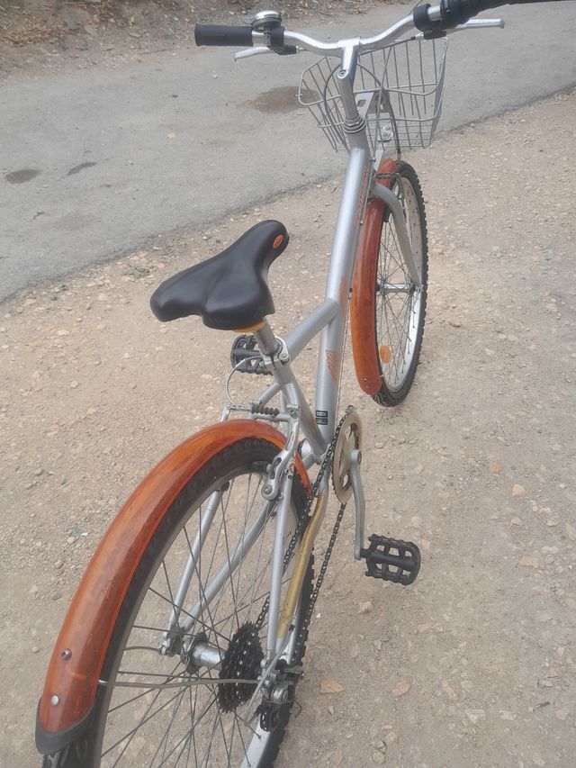 Bicicleta Decathlon plateada con cesta