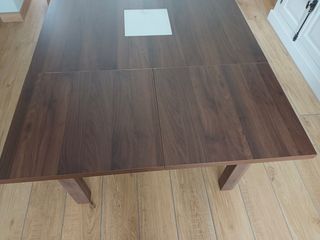 Mesa extensible de comedor de madera y cristal.