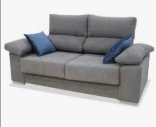 Sofá gris con cojines turquesa.