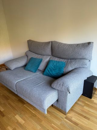 Sofá gris con cojines turquesa.