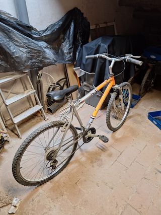 Bicicleta de montaña naranja y plateada