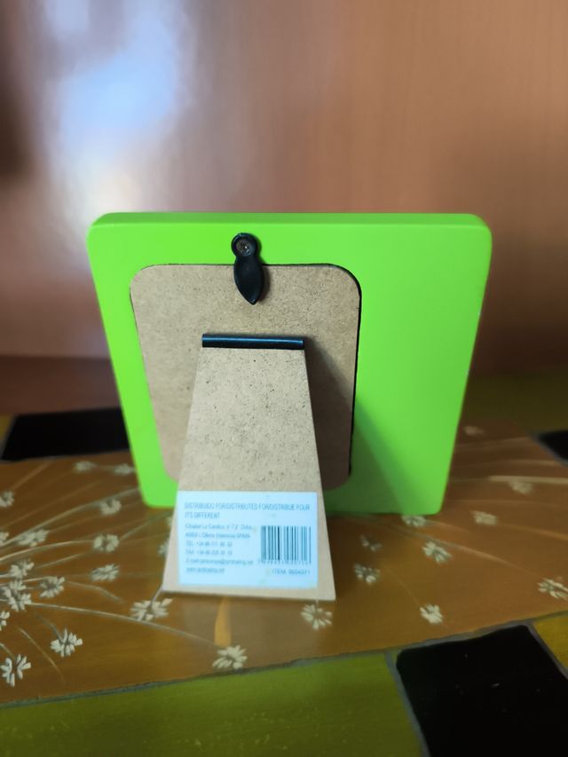 Portarretratos verde con flores rojas.