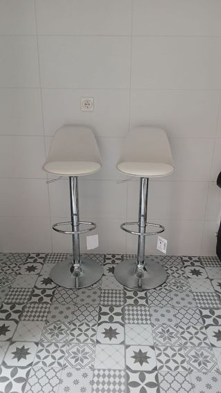 Taburetes regulables plateados y blancos