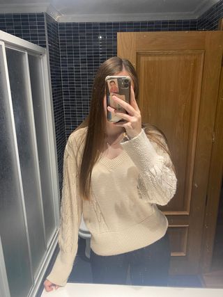 Jersey beige cuello pico y mangas de ochos.