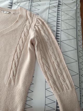 Jersey beige cuello pico y mangas de ochos.