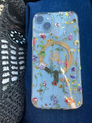 iPhone 14 Plus con flores secas