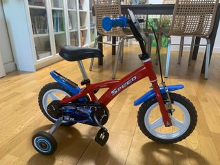 Bicicleta infantil roja con ruedas de aprendizaje