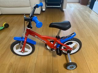 Bicicleta infantil roja con ruedas de aprendizaje