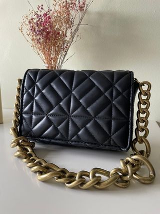 Bolso negro acolchado con cadena dorada