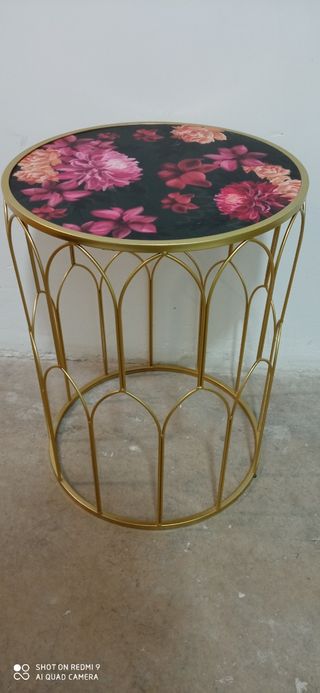Mesa auxiliar metálica dorada con flores