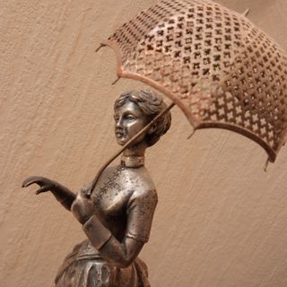 Figura dama con paraguas en metal