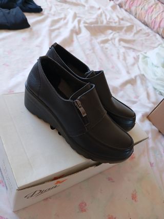 Mocasines negros de cuña con cremallera.