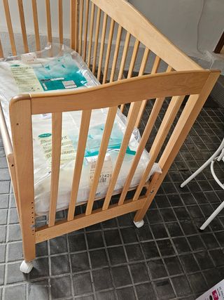 Cuna de madera con colchón para colecho.